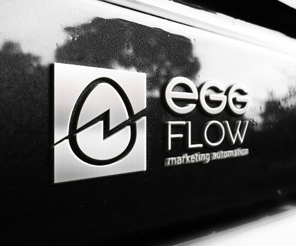 The EggFlow logo in its single-colour variant, embossed in silver on a dark surface