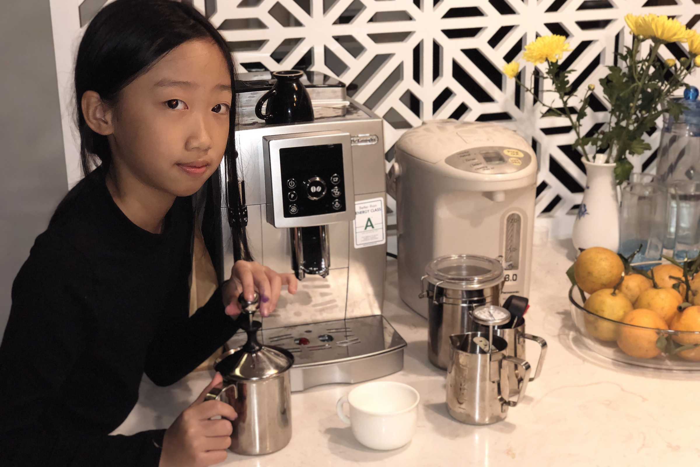 The young owner of Moon Coffee Bean steaming milk at the home-kitchen counter