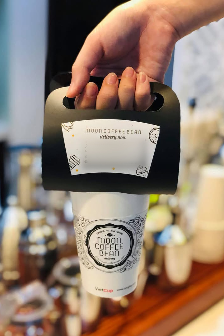 Paper carry handle · How to order again, right in the customer's hand Black paper carry handle clipped onto a Moon Coffee Bean takeaway cup