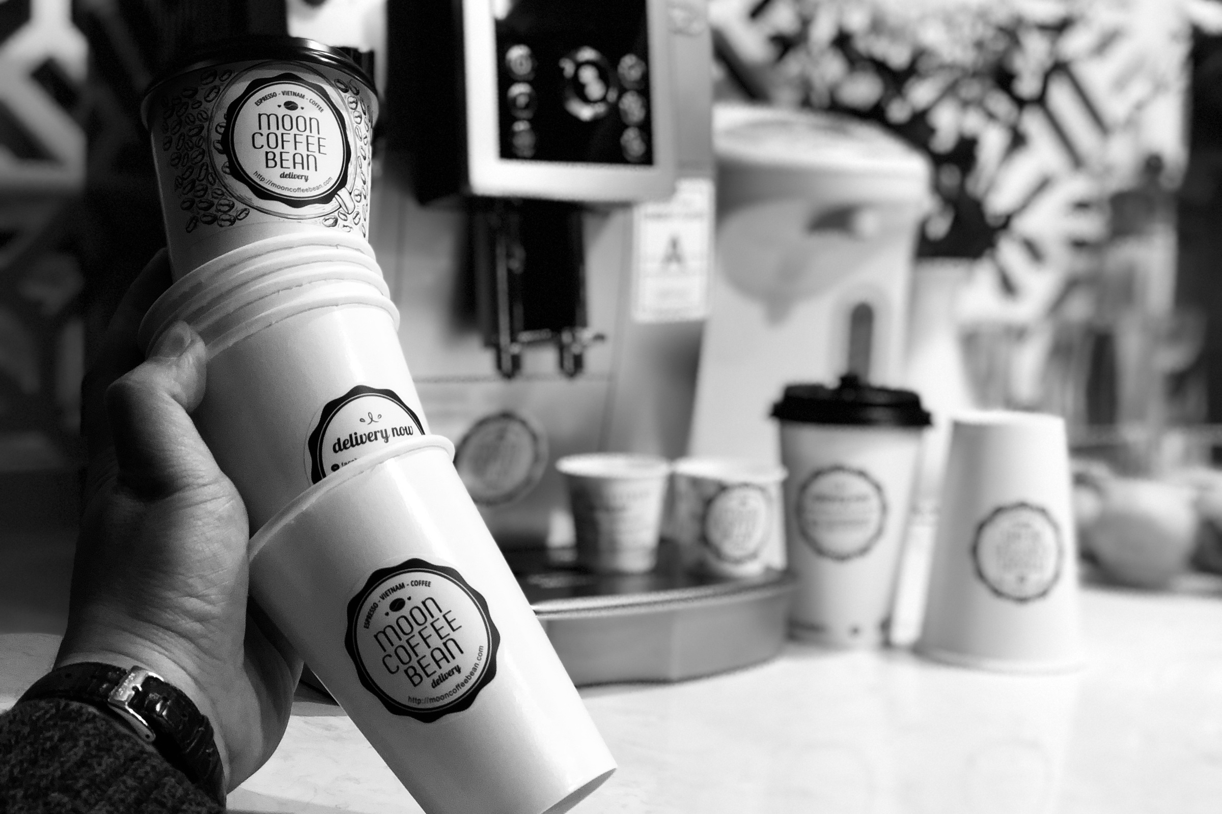 A stack of Moon Coffee Bean paper cups closed with round seal stickers